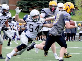 Sudbury Junior Spartans linebacker Colton Savage (54) attempts to tackle Huronia Stallions running back Michael Wallin (21) during Ontario Summer Football League U16 action at James Jerome Sports Complex in Sudbury, Ontario on Saturday, May 25, 2024.