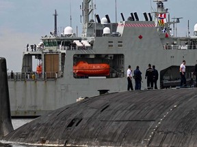 Russian Marines standing on top of the Russian nuclear-powered submarine Kazan (right), part of the Russian naval detachment visiting Cuba, watch Canada's HMCS Margaret Brooke, the second Harry DeWolf-class offshore patrol vessel for the Royal Canadian Navy (RCN), upon arrival in Havana Harbor on June 14, 2024.
