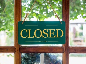 Stock photo of a closed sign on a wood/glass door