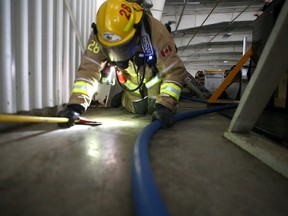 With their vision reduced, a firefighter feels their way through an obstacle course