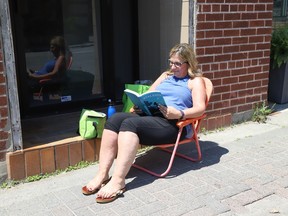 Tracey Urso reads a book while soaking in the sun during her lunch break in downtown Sudbury, Ont. on Tuesday June 18, 2024.