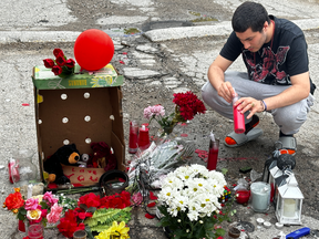 Abduljabbar Al-Samraei, 19, lights up a candle at a makeshift memorial created by friends of 18-year-old Abdul "Zeko" Hashim, who was killed Friday night in a public housing complex in south London. Photo taken on Sunday June 23, 2024. JONATHAN JUHA/The London Free Press