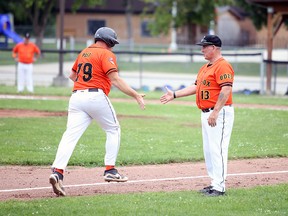 Bryan Post (left) celebrates with coach Don Bartley after Post smashed a home run while the Owen Sound Baysox host the New Lowell Knights at Tom Williams Park in Owen Sound Saturday afternoon. A "BD23" patch on the Baysox uniform is in memory of late teammate Bailey Durocher, honoured at the second annual Bailey Durocher Memorial Game. Greg Cowan/The Sun Times