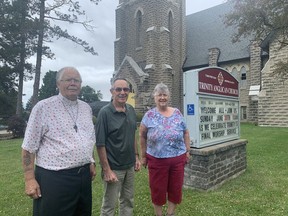 Reverend Bill Graham and church wardens DeWayne Hiltz and Sandy McDonald, in front of Trinity Anglican Church on Sunday, June 30 prior to the church's last service. The church is closing after serving the community since 1909.