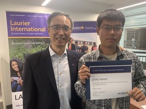 Ben Yang, director of global engagement at Wilfrid Laurier University with Ziyao Wang, of Chongqing Jiaotong University in China. Wang is holding a certificate he received Friday after completing the four-week business communication and entrepreneurship program at the Laurier Brantford campus. The international education program attracted at total of 15 students from South Korea and China.