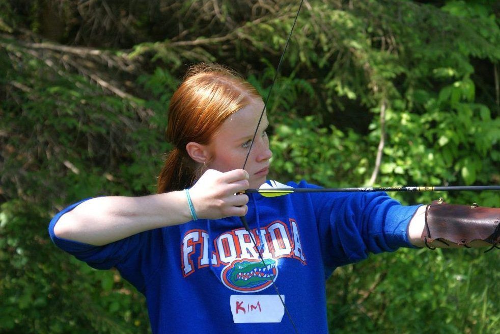 Kim Bishop aims a bow and arrow