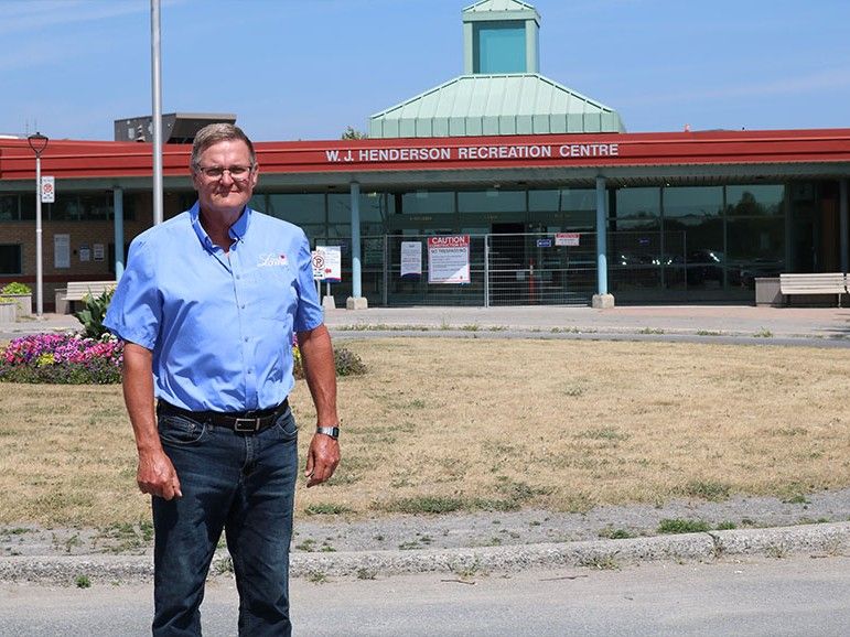 A man standing in front of a recreation facility.