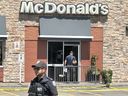 Toronto Police forensics officers investigate and dust for fingerprints as they probe the stabbing death of a male teen who was found at a McDonald's restaurant at Eastern Ave., just west of Coxwell Ave., in Toronto on Sunday, July 6, 2025.