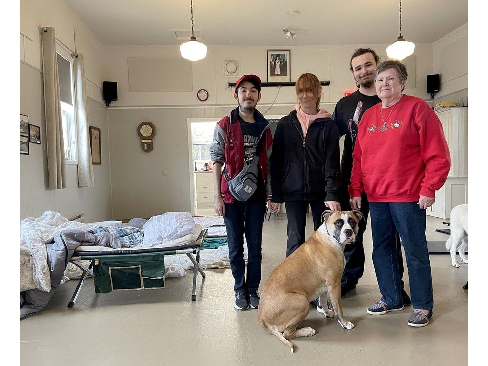 a family stands in a community hall after being evacuated from fire
