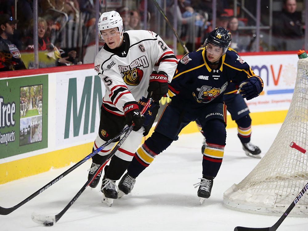 David Bedkowski fights off Justin Handsor and clears the puck in the second period as the Owen Sound Attack play the Barrie Colts inside the Harry Lumley Bayshore Community Centre on Wednesday, Oct. 15, 2025. Greg Cowan/The Sun Times