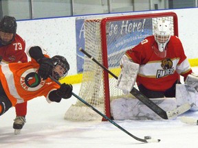 North Park Collegiate's Luc Savoie is taken down at the side of the net by Paris District High School's Keith McRuer as goaltender Ethan Sickle looks on during an AABHN boys hockey game at Brant Sports Complex on Monday, Dec. 15.
