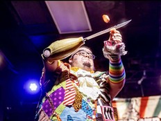 A man with a knife prosthetic cuts a carrot in his other hand