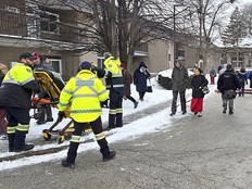 Paramedics with Chatham-Kent EMS are seen with a gurney as many residents leave the area after a fire happened at the apartment complex at 99 McNaughton Ave. W. in Chatham on Thursday. (Ellwood Shreve/Chatham Daily News)