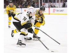 Kingston Frontenacs' Nolan Snyder tries to get past Sarnia Sting's Mitch Young