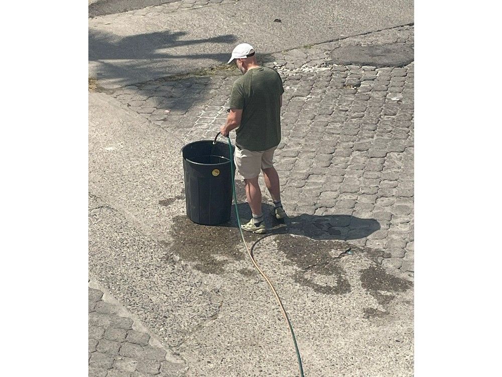  Mike Chilibeck from Ottawa fills a bucket to put out fires outside his rented villa near Puerto Vallarta’s Versalles district on Sunday.