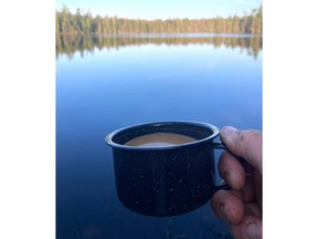 1st person view, morning cup of coffee beside a wilderness lake