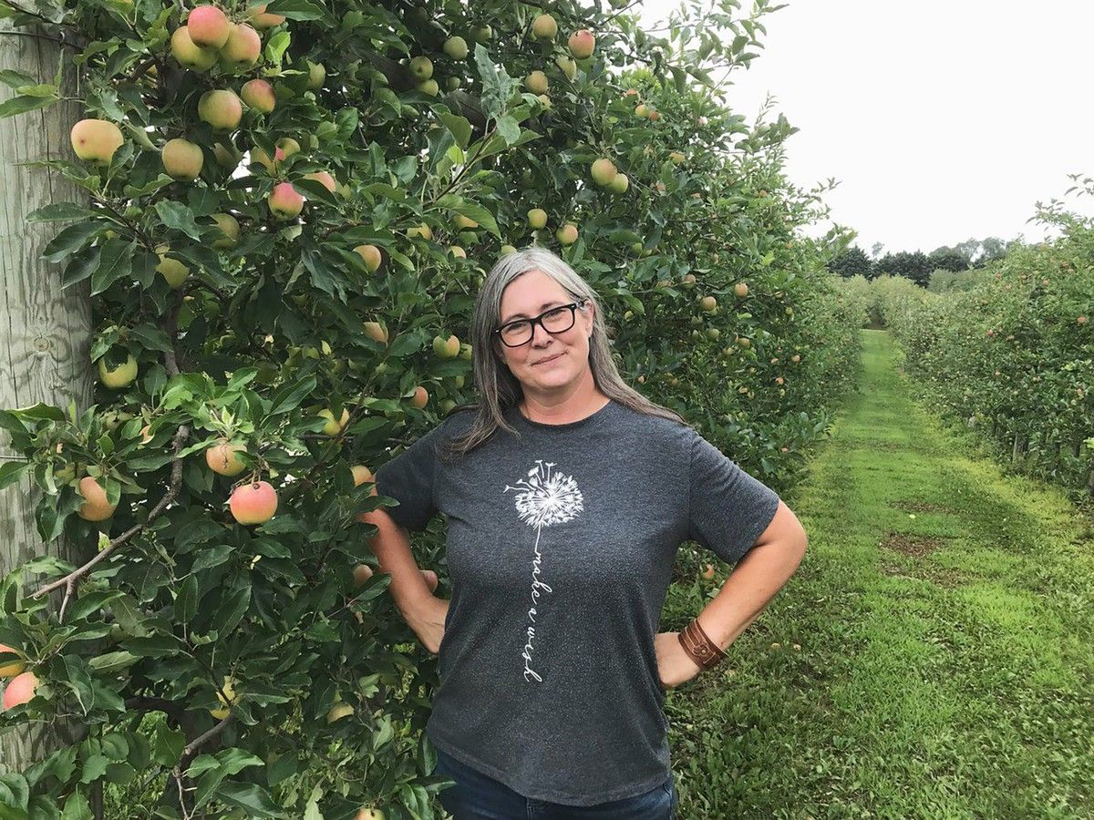Woman standing in apple orchard