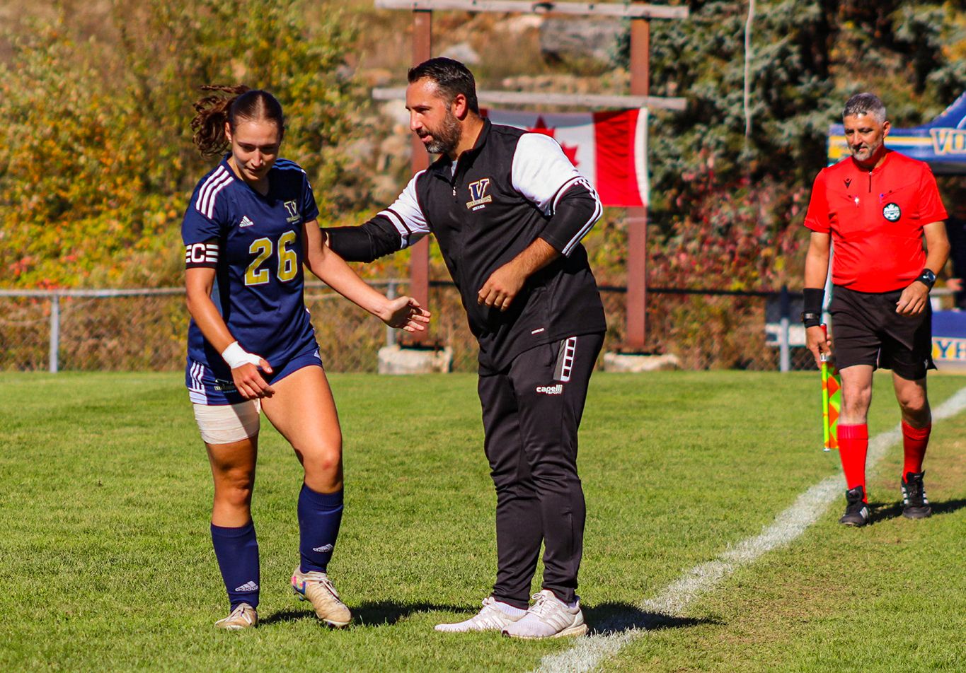 Laurentian Voyageurs varsity soccer head coach Randy Ribeiro speaks with defender Amelie Pires (26) during an OUA women's match in Sudbury