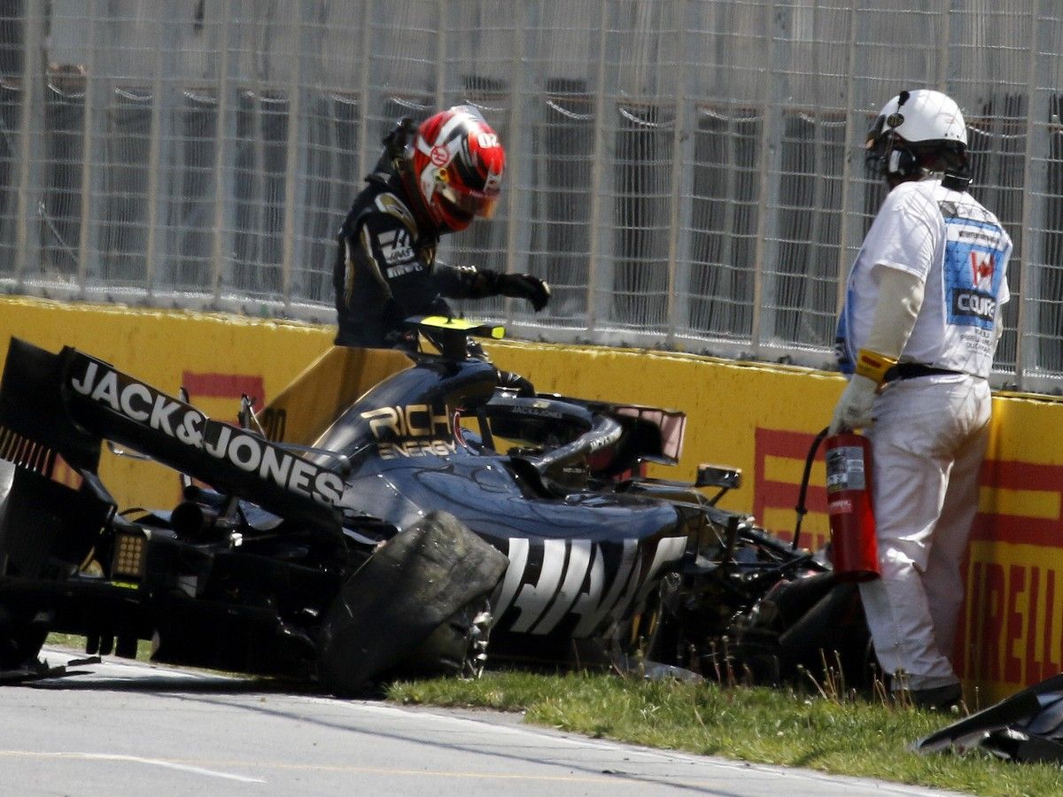 Kevin Magnussen, a crashed vehicle, and support team at Montreal Grand Prix