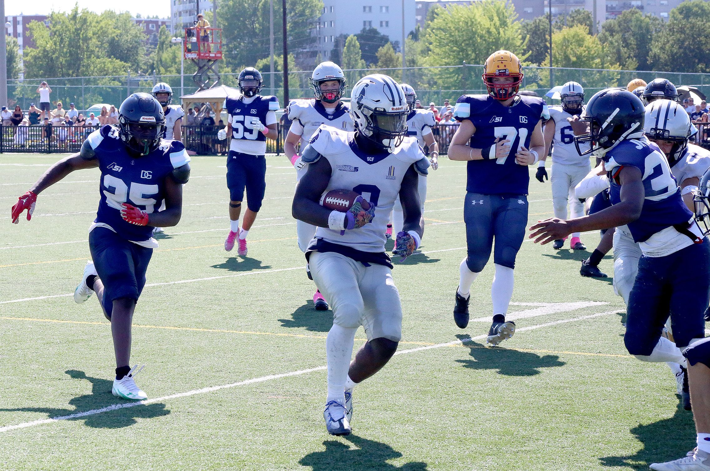 A football players runs with the ball