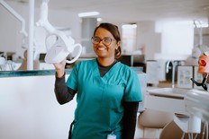 A dental assistant poses with equipment in the office