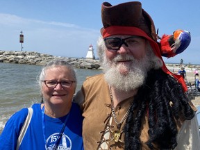 A man dressed as a pirate and his wife stand on the beach in front of Lake Huron for the annual marine festival in Southampton.