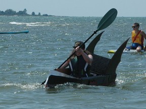 Grace Rooyakkers in her black Batman-themed cardboard boat in Lake Huron