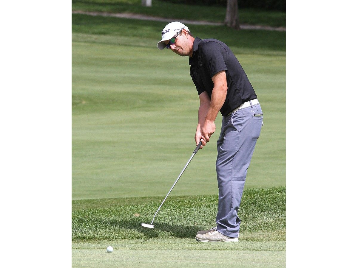 A man golfing on a putting green