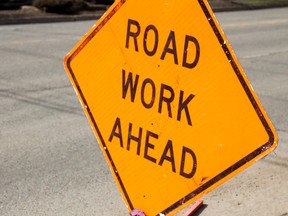 Road work ahead sign against asphalt road
