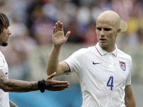 United States' Michael Bradley, right, congratulates his teammate Jermaine Jones after qualifying for the next World Cup round following their 1-0 loss to Germany during the group G World Cup soccer match between the USA and Germany at the Arena Pernambuco in Recife, Brazil, Thursday, June 26, 2014.