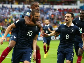 Karim Benzema of France celebrates scoring the first goal with Patrice Evra, Mathieu Valbuena during the 2014 FIFA World Cup Brazil Group E match between France and Honduras at Estadio Beira-Rio on June 15, 2014 in Porto Alegre, Brazil.  (Photo by Ian Walton/Getty Images)