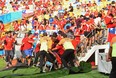 Security personnel try to control Chilean fans on the field of play entering the stands.  (Photo by David Ramos/Getty Images)