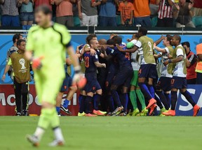 Netherlands' players celebrate after forward Robin van Persie (not seen) scored their team's fourth goal as Spain's goalkeeper Iker Casillas (L) returns to his goal during a Group B football match between Spain and the Netherlands at the Fonte Nova Arena in Salvador during the 2014 FIFA World Cup on June 13, 2014.      AFP PHOTO / JAVIER SORIANOJAVIER SORIANO/AFP/Getty Images