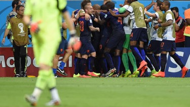 Netherlands' players celebrate after forward Robin van Persie (not seen) scored their team's fourth goal as Spain's goalkeeper Iker Casillas (L) returns to his goal during a Group B football match between Spain and the Netherlands at the Fonte Nova Arena in Salvador during the 2014 FIFA World Cup on June 13, 2014.      AFP PHOTO / JAVIER SORIANOJAVIER SORIANO/AFP/Getty Images