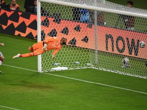 Germany's Andre Schuerrle (L) scores past Algeria goalkeeper Rais Mbohli during their Round of 16 match Monday in Porto Alegre, Brazil, during the 2014 FIFA World Cup. Germany won 2-1 to advance to the quarter-finals.