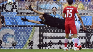 Iran's goalkeeper Alireza Haghighi dives but fails to stop a goal by Argentina's Lionel Messi during the group F World Cup soccer match between Argentina and Iran at the Mineirao Stadium in Belo Horizonte, Brazil, Saturday, June 21, 2014. Argentina defeated Iran 1-0. (AP Photo/Martin Meissner)