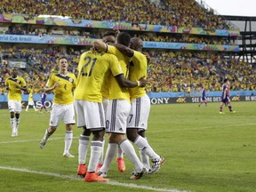 Colombia's players celebrate after scoring their second goal during the group C World Cup soccer match between Japan and Colombia at the Arena Pantanal in Cuiaba, Brazil, Tuesday, June 24, 2014. (AP Photo/Felipe Dana)