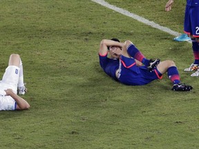 Greece's Vasilis Torosidis, left, and Japan's Maya Yoshida sit on the floor after colliding during the group C World Cup soccer match between Japan and Greece at the Arena das Dunas in Natal, Brazil, Thursday, June 19, 2014. (AP Photo/Hassan Ammar)