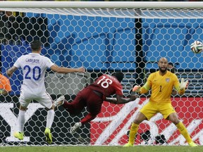 Portugal's Silvestre Varela heads the ball past United States' goalkeeper Tim Howard to score his side's second goal and tie the game 2-2 during the group G World Cup soccer match between the USA and Portugal at the Arena da Amazonia in Manaus, Brazil, Sunday, June 22, 2014. (AP Photo/Martin Mejia)