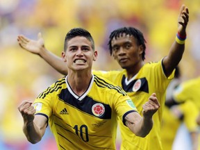 Colombia's James Rodriguez (10) celebrates with teammate Colombia's Juan Cuadrado after scoring his side's first goal during the group C World Cup soccer match between Colombia and Ivory Coast at the Estadio Nacional in Brasilia, Brazil, Thursday, June 19, 2014. (AP Photo/Fernando Llano)