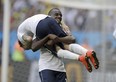 France's Blaise Matuidi carries his teammate Mathieu Valbuena as they celebrate at the end of the World Cup round of 16 soccer match between France and Nigeria at the Estadio Nacional in Brasilia, Brazil, Monday, June 30, 2014. France won 2-0 to reach the World Cup quarterfinals. (AP Photo/Ricardo Mazalan)