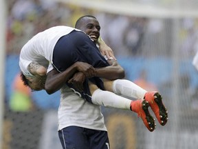 France's Blaise Matuidi carries his teammate Mathieu Valbuena as they celebrate at the end of the World Cup round of 16 soccer match between France and Nigeria at the Estadio Nacional in Brasilia, Brazil, Monday, June 30, 2014. France won 2-0 to reach the World Cup quarterfinals. (AP Photo/Ricardo Mazalan)