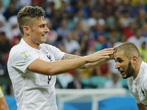 France's Olivier Giroud, left, touches the head of Karim Benzema during the group E World Cup soccer match between Switzerland and France at the Arena Fonte Nova in Salvador, Brazil, Friday, June 20, 2014.  (AP Photo/David Vincent)