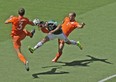 Mexico's Hector Herrera, center, challenges for the ball with Netherlands' Stefan de Vrij, left, and Ron Vlaar during the World Cup round of 16 soccer match between the Netherlands and Mexico at the Arena Castelao in Fortaleza, Brazil, Sunday, June 29, 2014. (AP Photo/Themba Hadebe)