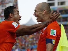 Netherlands' Memphis Depay, left, celebrates with teammate Arjen Robben after scoring his side's second goal during the group B World Cup soccer match between the Netherlands and Chile at the Itaquerao Stadium in Sao Paulo, Brazil, Monday, June 23, 2014. (AP Photo/Frank Augstein)