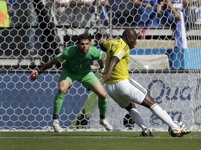 Colombia's Pablo Armero, right, kicks the ball at Greece's goalkeeper Orestis Karnezis to score his side's first goal during the group C World Cup soccer match between Colombia and Greece at the Mineirao Stadium in Belo Horizonte, Brazil, Saturday, June 14, 2014. (AP Photo/Fernando Vergara)