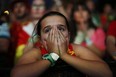A Spanish soccer fan covers her face as she watches. . (Associated Press Photo/Andres Kudacki)