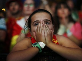 A Spanish soccer fan covers her face as she watches. . (Associated Press Photo/Andres Kudacki)