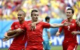 Switzerland's Xherdan Shaqiri, center, celebrates with teammate  Goekhan Inler, left, and Stephan Lichtsteiner (2) after scoring during the group E World Cup soccer match between Honduras and Switzerland at the Arena da Amazonia in Manaus, Brazil, Wednesday, June 25, 2014. (AP Photo/Felipe Dana)