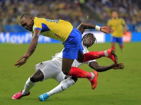 Ecuador's Walter Ayovi collides with France's Bacary Sagna during the group E World Cup soccer match between Ecuador and France at the Maracana Stadium in Rio de Janeiro, Brazil, Wednesday, June 25, 2014. (AP Photo/Bernat Armangue)